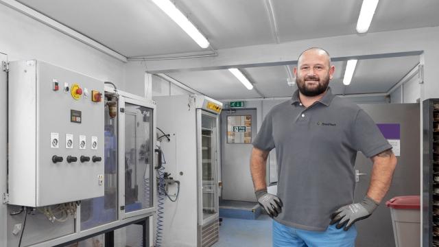 man standing next to a switch board